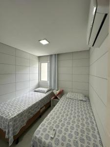嘎林海斯港的住宿－Casa de Luxo, 1 quadra do Mar em Porto de Galinhas，一间卧室设有两张床和窗户。