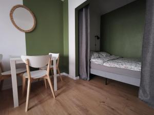 ein Schlafzimmer mit einem Bett, einem Tisch und einem Stuhl in der Unterkunft Apartament Skałka in Świętochłowice