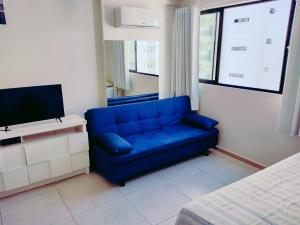 a blue couch in a small room with a tv at Home Boa Viagem in Recife