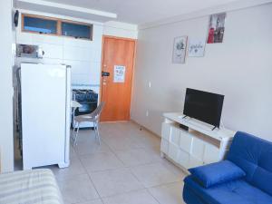 a living room with a blue couch and a tv at Home Boa Viagem in Recife