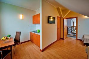 a kitchen and a dining room with a table and a room at HL Łebski Apartamenty in Łeba