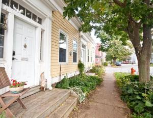 einem Hund, der auf einer Veranda eines Hauses sitzt in der Unterkunft Heritage Townhouse in Downtown Halifax in Halifax