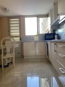 kuchnia ze zlewem, stołem i krzesłem w obiekcie Cagnes-sur-Mer, 50m de la mer, au calme w Cagnes-sur-Mer +6 zdjęć