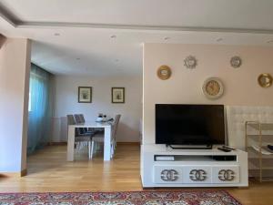 salon z telewizorem i stołem z krzesłami w obiekcie Cagnes-sur-Mer, 50m de la mer, au calme w Cagnes-sur-Mer