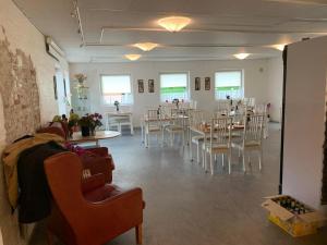 a dining room with tables and chairs and windows at Marskture Hostel in Højer