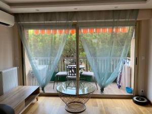 pokój ze szklanym stołem przed balkonem w obiekcie Cagnes-sur-Mer, 50m de la mer, au calme w Cagnes-sur-Mer