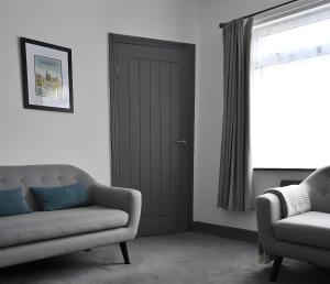 a living room with a couch and a door at Emerson - homely 3 bedroom sleeps 6 Free Parking & WiFi in Woodhorn
