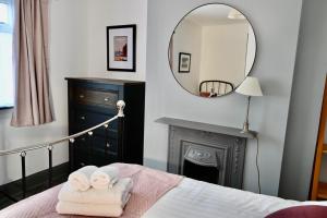 a bedroom with a bed with towels and a mirror at Emerson - homely 3 bedroom sleeps 6 Free Parking & WiFi in Woodhorn