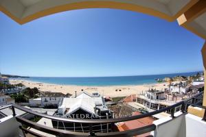 uitzicht op het strand vanaf het balkon van een gebouw bij Residencial Sol in Portimão