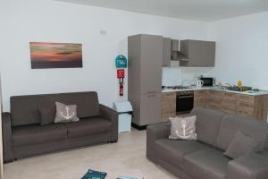 uma sala de estar com dois sofás e uma cozinha em Central Modern Apartment 1 Bedroom em Il-Gżira