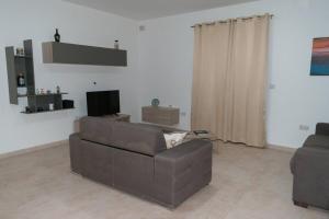 uma sala de estar com um sofá castanho e uma televisão em Central Modern Apartment 1 Bedroom em Il-Gżira