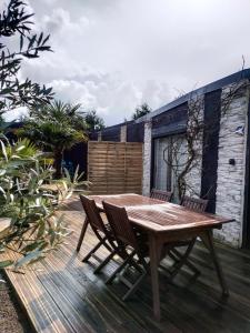 a wooden table and chairs on a wooden deck at Émeraude in Penmarch