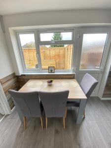 een tafel en stoelen in een kamer met een raam bij Gatwick Studio in Horley