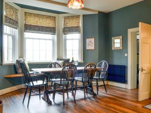 uma sala de jantar com mesa e cadeiras em The Old Vicarage em Westward