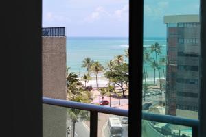 uma vista para a praia a partir da janela do hotel em Maceio Ferias apto com varanda vista mar em Maceió