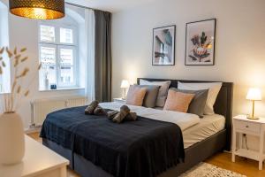 Un dormitorio con una cama con dos ositos de peluche. en Fynbos Apartments in der Altstadt, Frauenkirche, Netflix, Parkplatz, en Meißen