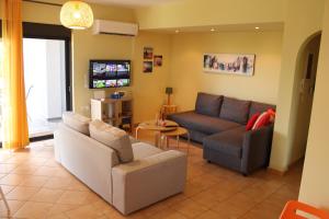 a living room with two couches and a tv at T&A Apartment,near the sea. in Marathón