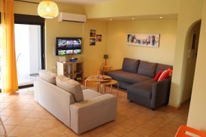 a living room with two couches and a tv at T&A Apartment,near the sea. in Marathon