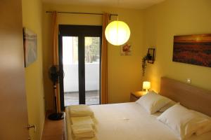 um quarto com uma cama branca e uma janela em T&A Apartment,near the sea. em Marathón
