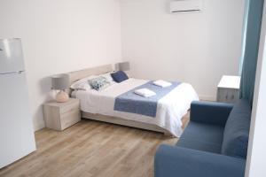 a bedroom with a bed and a blue chair at SDH apartments in Alicante