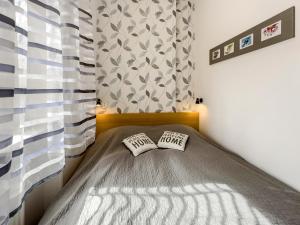 um pequeno quarto com uma cama e uma cortina em Laura´s Apartment em Karlovy Vary