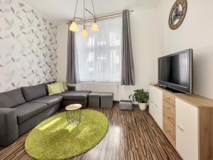 uma sala de estar com um sofá e uma televisão em Laura´s Apartment em Karlovy Vary