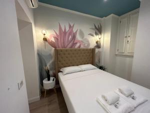 ein kleines Zimmer mit einem Bett und einer an der Wand gemalten Blume in der Unterkunft Raffaello's Place in Rom