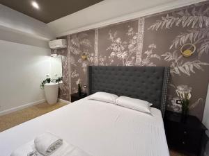 ein Schlafzimmer mit einem Bett und einer Wand mit Blumen in der Unterkunft Raffaello's Place in Rom