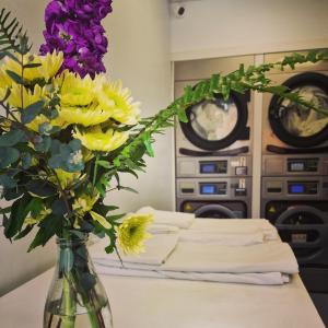 un jarrón lleno de flores amarillas y moradas en una mesa en Albergue Albor, en Caldas de Reis