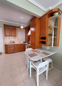 a kitchen with a white table and white chairs at Orange Tree Apartment in Asprovalta