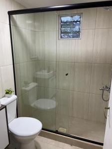 uma casa de banho com um chuveiro, um WC e uma janela. em Ohana 1 em Puerto Iguazú