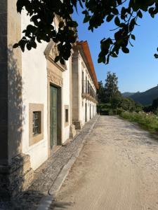 an empty road next to a white building at Casa da Agrela in Ponte da Barca