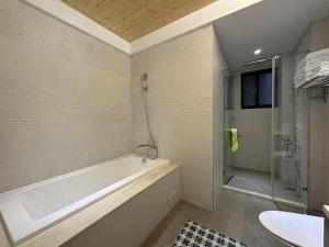 高雄親子溜滑梯High Fun旅店 في كاوشيونغ: حمام مع حوض استحمام ودش ومغسلة