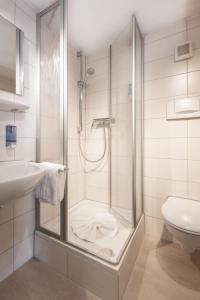 y baño con ducha y lavamanos. en Landgasthof Augustiner, en Oberstdorf