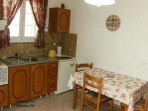 a kitchen with a table and a sink and a table and chairs at Apartments Mary in Agios Gordios +109 photos