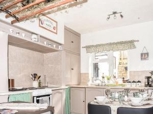 a kitchen with a sink and a table with chairs at Elms Cottage in Long Newton