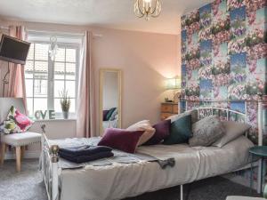 a living room with a bed and a couch at Elms Cottage in Long Newton