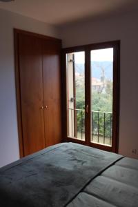 比拉德勞的住宿－‘El racó del bandoler’，一间卧室设有一张床和一个大窗户