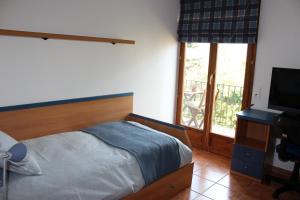 a bedroom with a bed and a flat screen tv at ‘El racó del bandoler’ in Viladrau