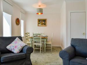 uma sala de estar com duas cadeiras e uma mesa em India Lane Cottage em Montrose