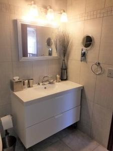 Baño blanco con lavabo y espejo en Your home in Colorado Springs en Colorado Springs