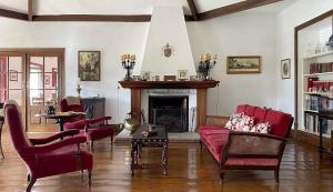 a living room with red chairs and a fireplace at Casa da Agrela in Ponte da Barca