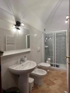 Baño blanco con lavabo y aseo en IN MEDIA URBE - intero appartamento, en LʼAquila