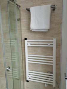 eine Dusche mit einem weißen Handtuch und einem Handtuchhalter in der Unterkunft Day Ok Beach Apartment in Malgrat de Mar