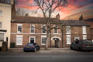 a brick house with two cars parked in front of it at Cottage Buttercup Yarm in Stockton-on-Tees