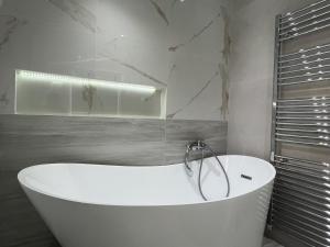 eine weiße Badewanne im Bad mit Marmorwänden in der Unterkunft Villa Ampelaki 2 in Paleokastritsa