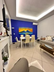 un soggiorno con tavolo e parete blu di Dimora Anema e Core a Napoli