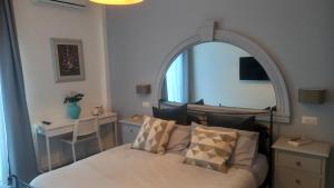 Schlafzimmer mit einem Bett und einem großen Spiegel in der Unterkunft Le Spiagge in Letojanni