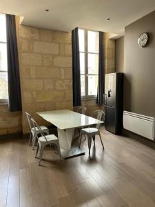 uma cozinha com uma mesa e cadeiras e um frigorífico em Wonderful T3 in old town em Bordeaux