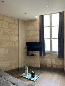 Il comprend un salon doté d'un canapé et d'une télévision à écran plat. dans l'établissement Wonderful T3 in old town, à Bordeaux